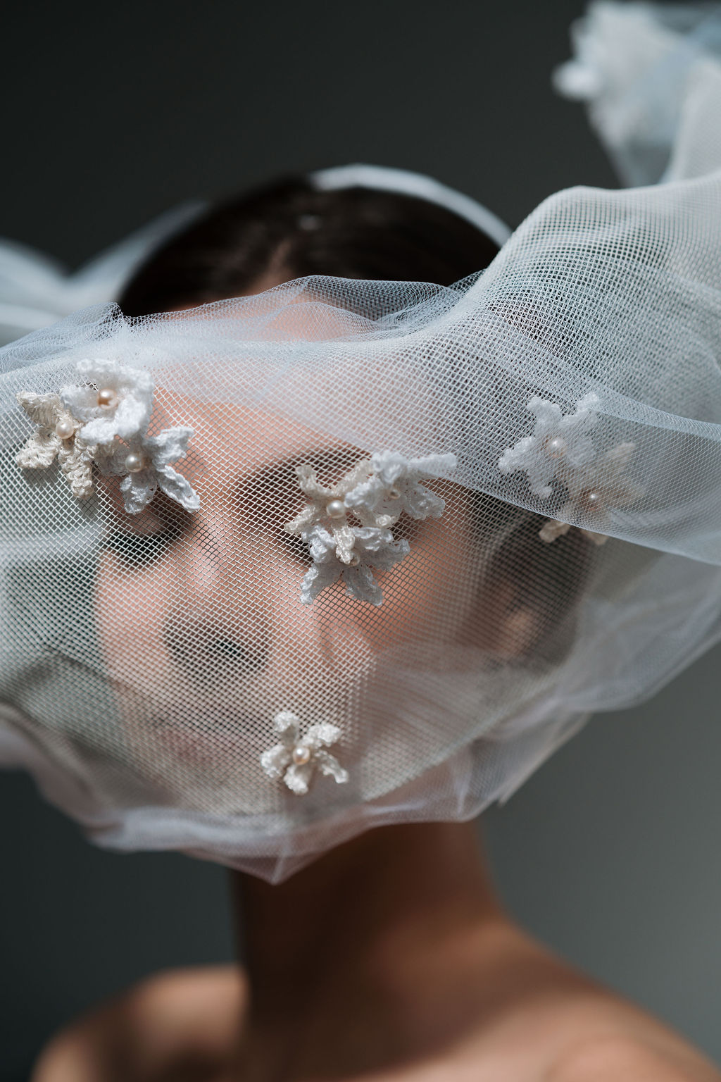 Headpiece by Roberta Cucuzza, made with crochet jasmine flowers, mesh and tulle. It resembles wind going around the wearers's face.